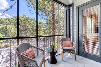 a porch with two chairs and a table and a window at The Beck at Hidden River, Tampa, Florida